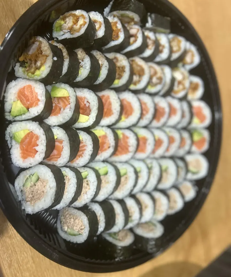 A Blessings platter of salmon avocado, chicken katsu and tuna rolls on a black tray